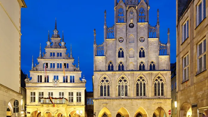 Historisches Rathaus mit beleuchteter Fassade in der blauen Stunde
